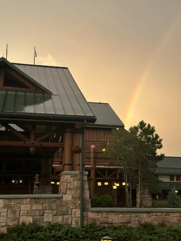 Close-up of the timber-and-stone porte-cochère — the lodge takes its cues from the historic Old Faithful Inn and the great national-park lodges.