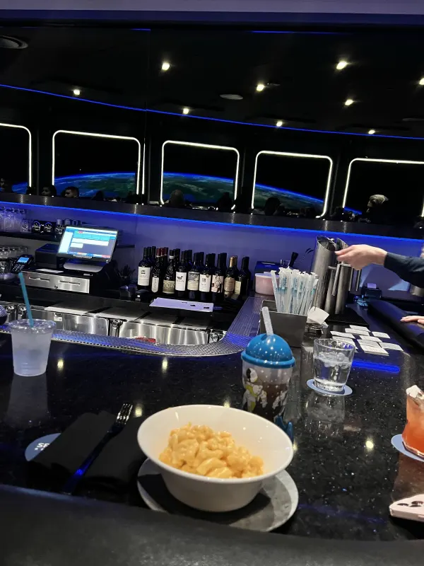 Tableside view of Earth from the lounge tables — the same window wall runs continuously across both halves.