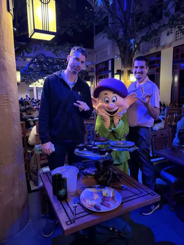 Dopey makes his rounds in silent pantomime — he plays the bit with every party at the table.