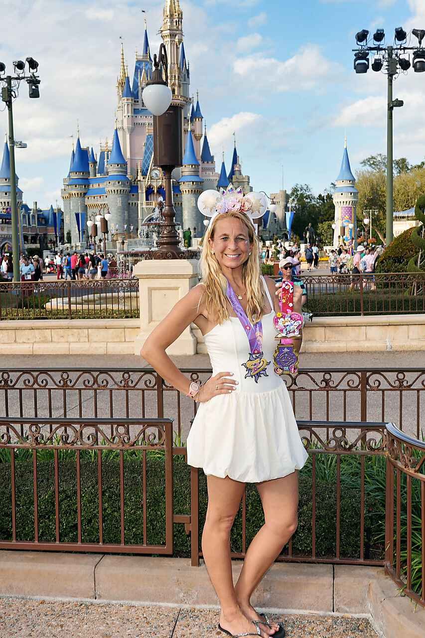 Fairytale Dreamers runner with medals in front of Cinderella Castle